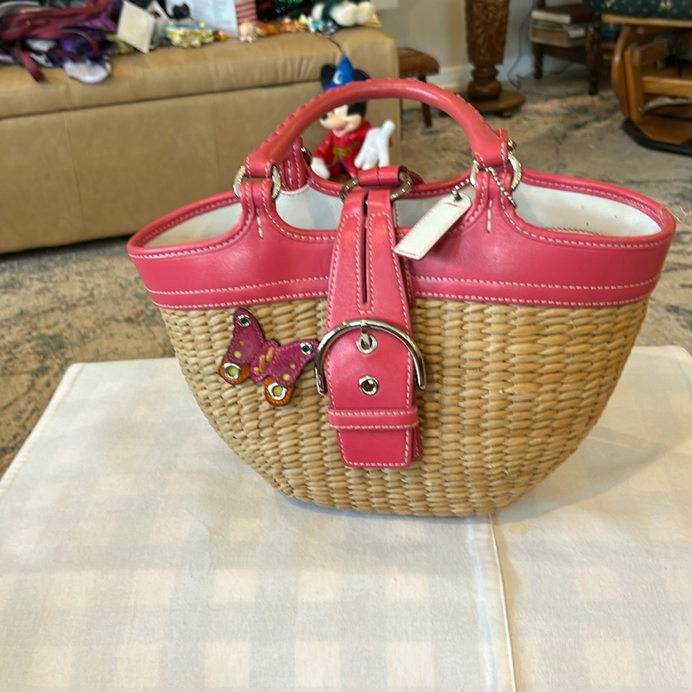 Coach, straw and pink leather handled bag with snap closure pink lining